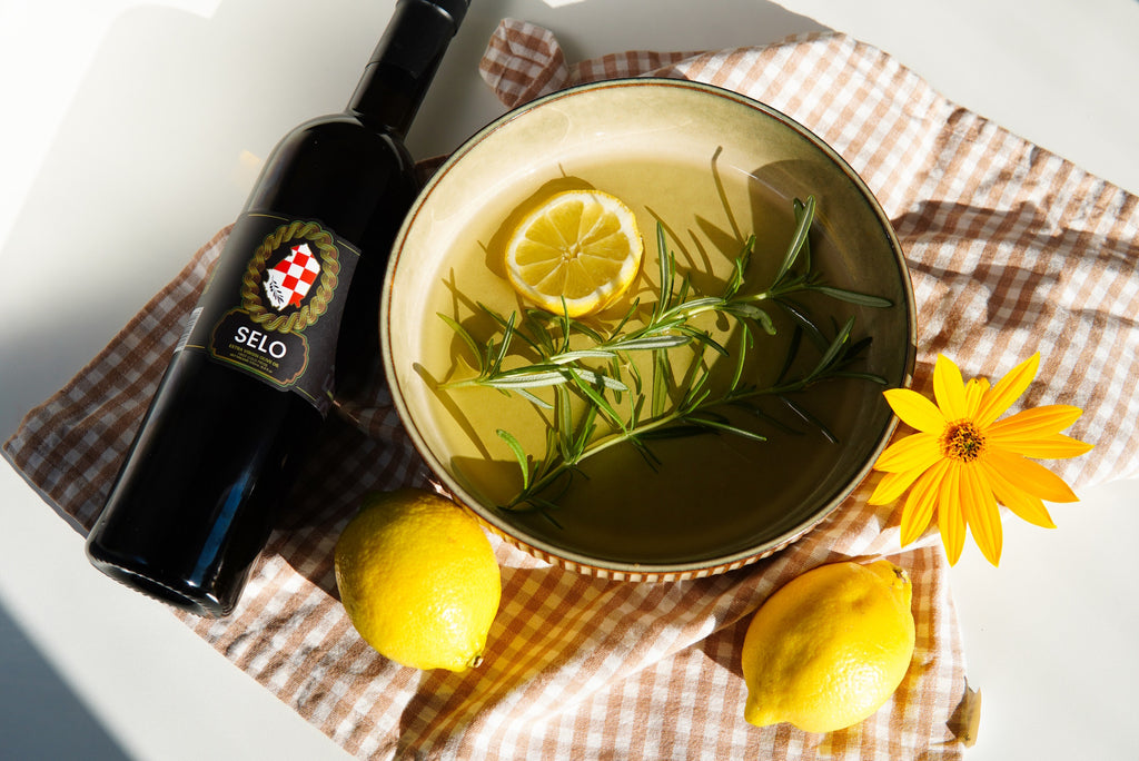 A bowl containing a vibrant medley of lemon slices, fragrant rosemary sprigs, and olive oil, showcasing a delightful combination while also hinting at the practice of oil pulling for potential oral health benefits.