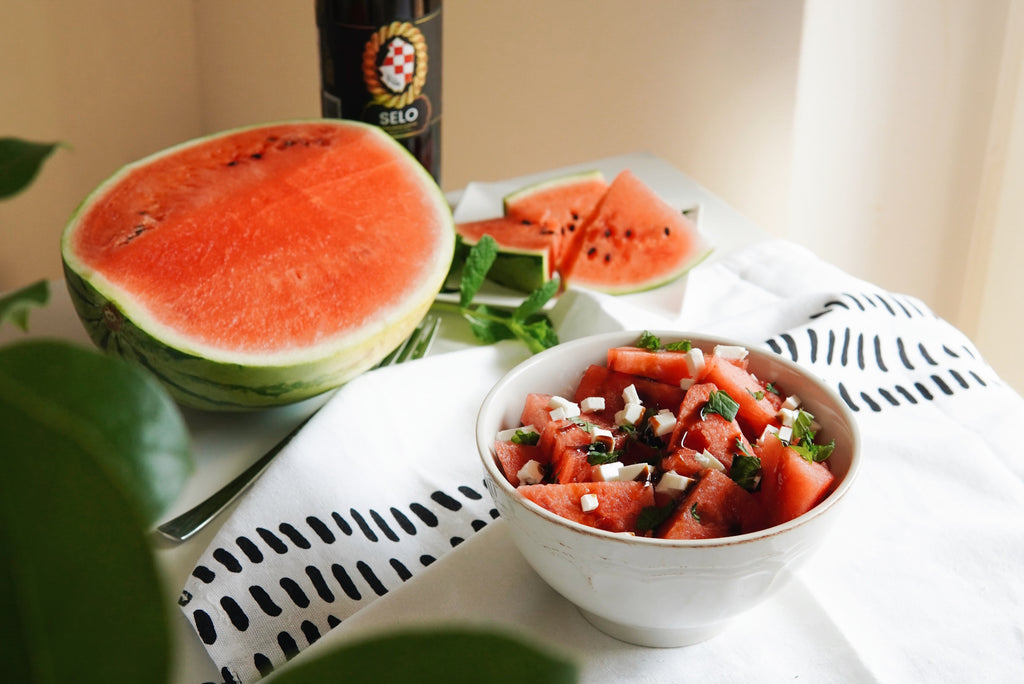 Refreshing Watermelon Feta Salad drizzled with robust Selo Croatian Extra Virgin Olive Oil, served in a bowl and garnished with fresh mint leaves